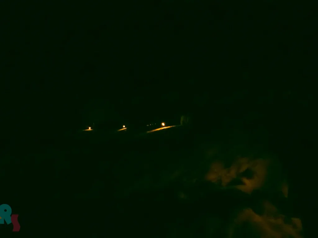 Einzelne Lichter in der dunklen Schneelandschaft.
